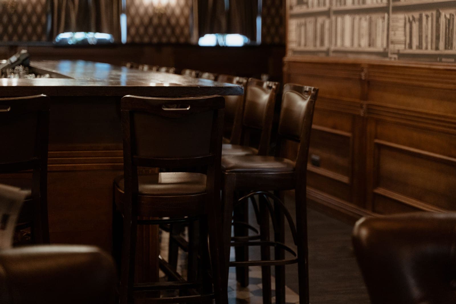 Two dark bar stools in a low-lit lounge